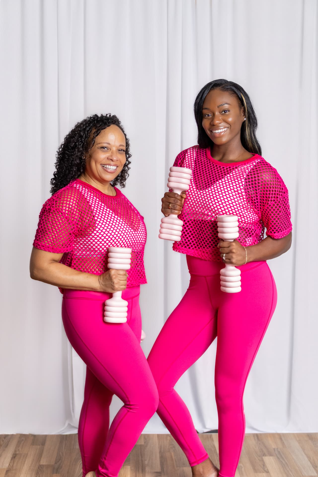 Jocelyn and Olivia smiling together in matching pink Fit & Fab workout outfits